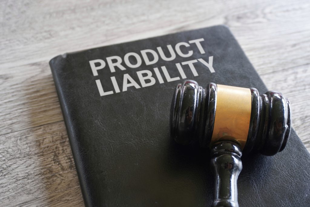 Close-up of gavel and small chalkboard with “product liability” written on it.