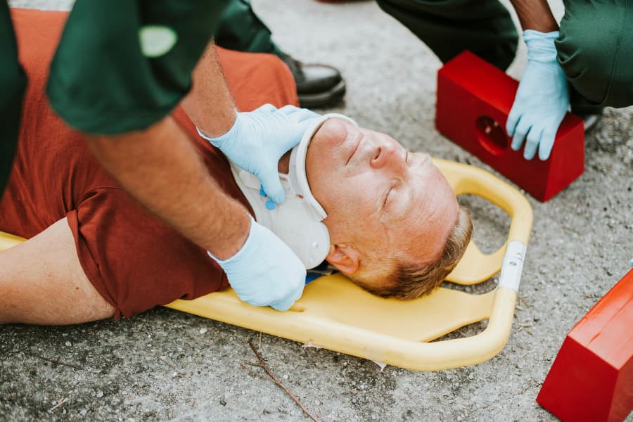 Paramedic s placing a cervical collar on an injured man.